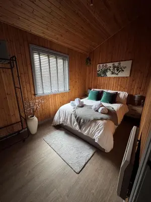 a bedroom with a large bed with green pillows at Fig Tree Lodge in Ellonby