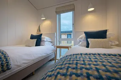 two beds in a room with a window at Bluebell Lodge in Girthon