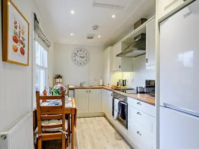 a kitchen with a table and a clock on the wall at 1 Bed in Maybole 93562 in Maybole