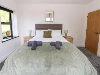 a bedroom with a large bed with purple towels on it at Oaktree Cottage - 3 Bedrooms - Sleeps 6 in Frizington