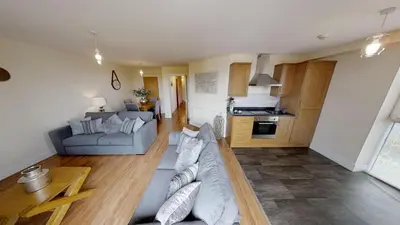 a living room with a couch and a kitchen at Lovely Furnished Apartment 2 in Carlisle