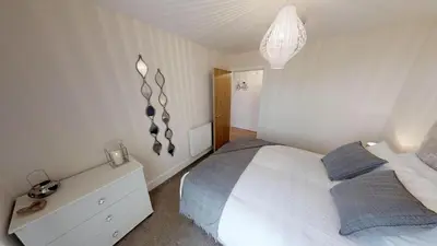a bedroom with a white bed with blue pillows at Lovely Furnished Apartment 2 in Carlisle