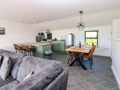 a living room and kitchen with a couch and a table at Sycamore Cottage - 2 Bedrooms - Sleeps 4 in Frizington