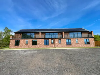 a large brick building with a solar roof at Sycamore Cottage - 2 Bedrooms - Sleeps 4 in Frizington