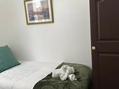 a bedroom with a bed with a green pillow at Athol House in Douglas