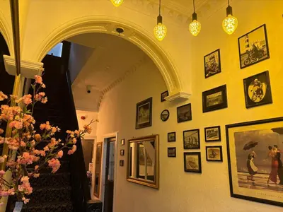 a hallway with a staircase with pictures on the wall at Athol House in Douglas
