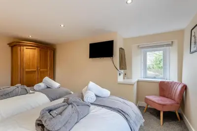 a bedroom with two beds and a tv and a chair at 3 Bed in Isel oc-i30816 in Sunderland