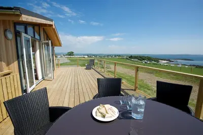a table with a plate of food on a balcony at Barley Lodge in Girthon