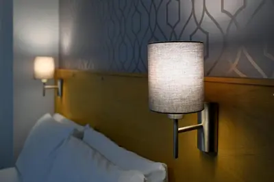 a lamp on a wall next to a bed at Corner House Hotel in Annan