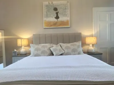 a bedroom with a large white bed with two lamps at Park Cottage - Spacious & Luxurious Room in B Listed Cottage in Moffat