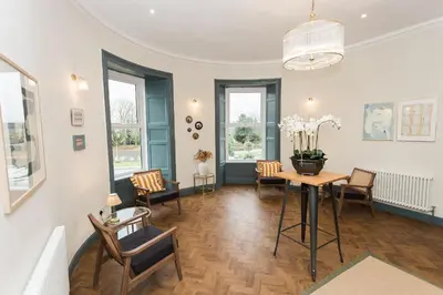 a living room with a table and chairs at Bedroom 2 - Rockcliffe in Dumfries