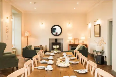 a dining room with a long table and chairs at Bedroom 2 - Rockcliffe in Dumfries