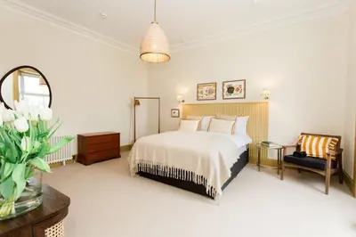 a bedroom with a bed and a chair and a mirror at Bedroom 2 - Rockcliffe in Dumfries