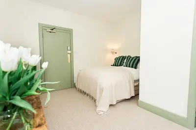 a bedroom with a bed and a green door at Torr House Hotel in Dumfries