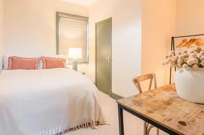 a bedroom with a bed and a table with a vase of flowers at Torr House Hotel in Dumfries
