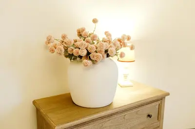 a white vase with flowers sitting on a table at Torr House Hotel in Dumfries
