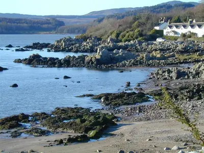 a view of a beach with rocks and houses at Colbeine in Rockcliffe