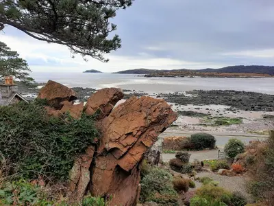 a large rock sitting next to a body of water at Colbeine in Rockcliffe
