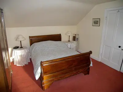 a bedroom with a bed and two tables with lamps at Colbeine in Rockcliffe