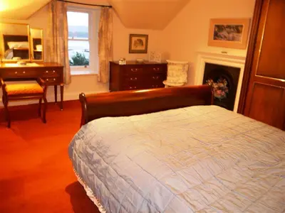 a bedroom with a bed and a desk and a fireplace at Colbeine in Rockcliffe