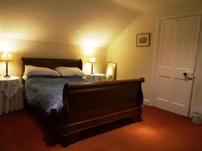 a bedroom with a bed with two lamps and a door at Colbeine in Rockcliffe