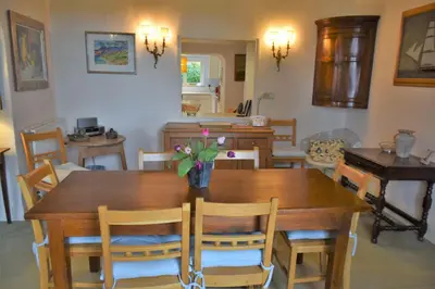 a dining room with a wooden table and chairs at Craigrathan in Kippford