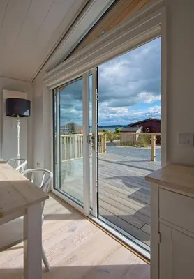 a sliding glass door with a view of a deck at Crabtree Lodge in Girthon