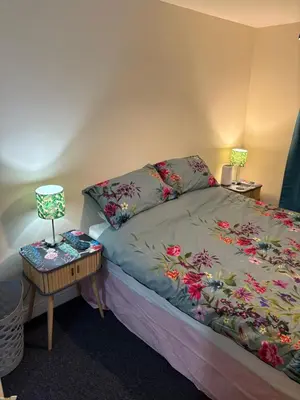 a bedroom with a bed and a table with a lamp at Maryport town centre cosy home in Maryport