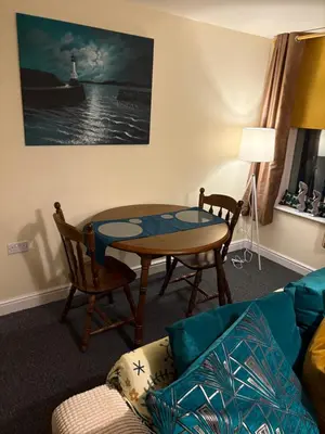 a living room with a table and a couch at Maryport town centre cosy home in Maryport