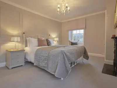 a bedroom with a large bed and a chandelier at 5 Bed in Cockermouth oc-sz424 in Lorton