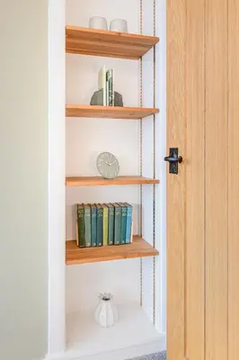 a book shelf filled with books next to a door at Cozy Lake District House on the fells in Ambleside