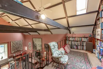 a room with a library with a chair and bookshelves at Lochpatrick Mill in Castle Douglas