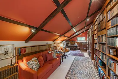 a library with a couch and a lot of books at Lochpatrick Mill in Castle Douglas