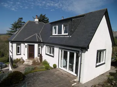 a white house with a black roof at Lonsdale in Rockcliffe