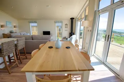 a living room with a table with a vase on it at Granary Lodge in Girthon