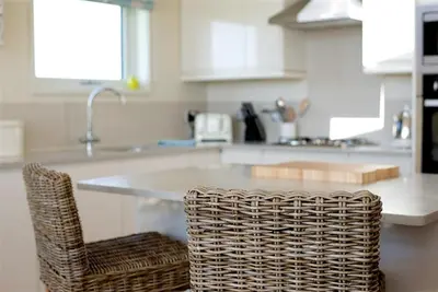 a kitchen with a counter with a wicker chair at Granary Lodge in Girthon