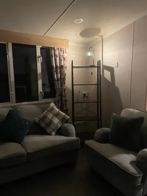 a living room with a couch and a chair at Lakes Escapes in Lamplugh