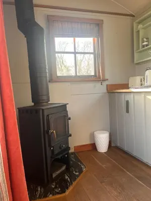a black stove in a kitchen with a window at Highland Hideaway in Wigton