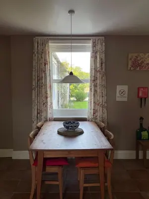 a dining room table and a window with a bowl on it at Barcloy Milk House in Kirkcudbright