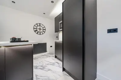 a kitchen with stainless steel cabinets and a clock on the wall at Modern Town House In Cockermouth in Cockermouth