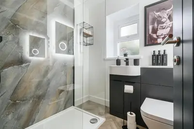a bathroom with a shower and a toilet and a sink at Modern Town House In Cockermouth in Cockermouth