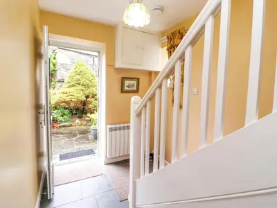a hallway with stairs and a door to a garden at Maiden Moor in Keswick