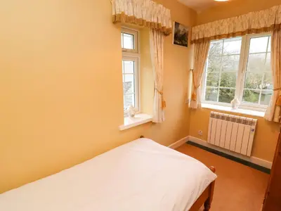 a bedroom with a bed and two windows at Maiden Moor in Keswick