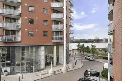 an apartment building with a parking lot in front of it at Apartment In Canary Wharf, London in Moffat