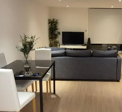a living room with a couch and a table at Apartment In Canary Wharf, London in Moffat