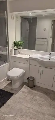 a bathroom with a toilet and a sink and a mirror at Apartment In Canary Wharf, London in Moffat
