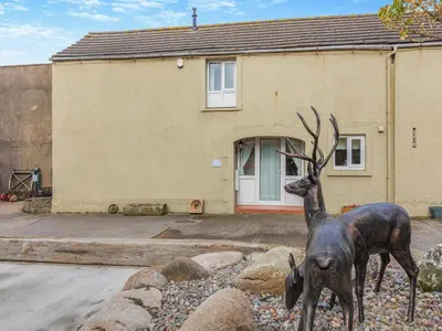 a statue of a deer in front of a house at Turnip House - Uk48909 in Allonby