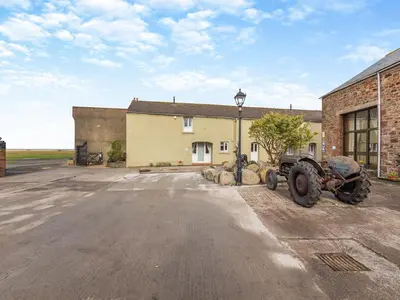 a tractor parked in a parking lot in front of a building at Turnip House - Uk48909 in Allonby