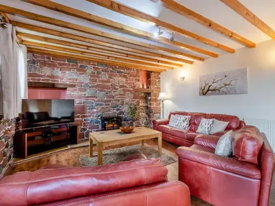 a living room with leather furniture and a brick wall at Barley Store - Uk48910 in Allonby