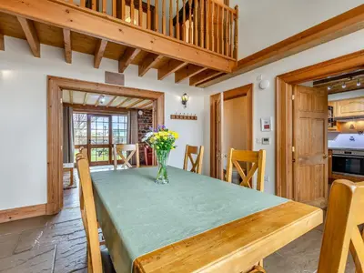 a dining room with a table with a vase of flowers at Barley Store - Uk48910 in Allonby